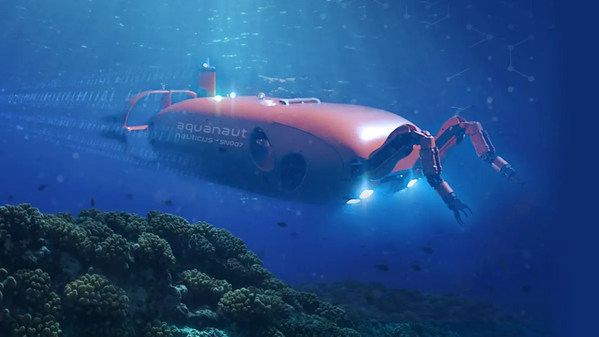 Robot viễn dương Aquanaut ở chế độ AUV đang bơi qua rạn san hô dưới biển sâu, đèn Led chiếu sáng đường đi.