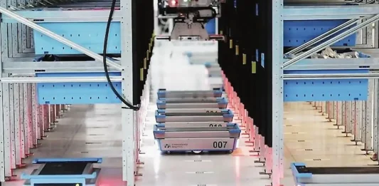 Đội ngũ robot logistics hoạt động với mật độ cao, luồn dưới kệ hàng tại trung tâm phân phối thương mại điện tử.