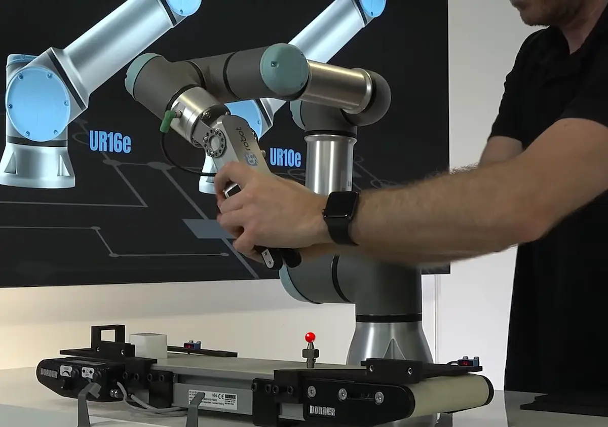 Cận cảnh chuyên gia đang thao tác và cấu hình cánh tay robot cộng tác UR20 tại xưởng kiểm thử RobotWorks, thể hiện thiết kế khớp xoay thế hệ mới trơn láng.