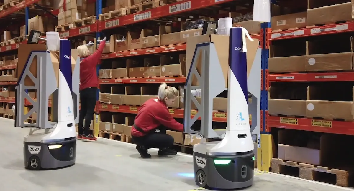 Công nhân thực hiện thao tác nhặt hàng lẻ (Discrete-item picking) phối hợp cùng robot Locus Origin tại kệ hàng.