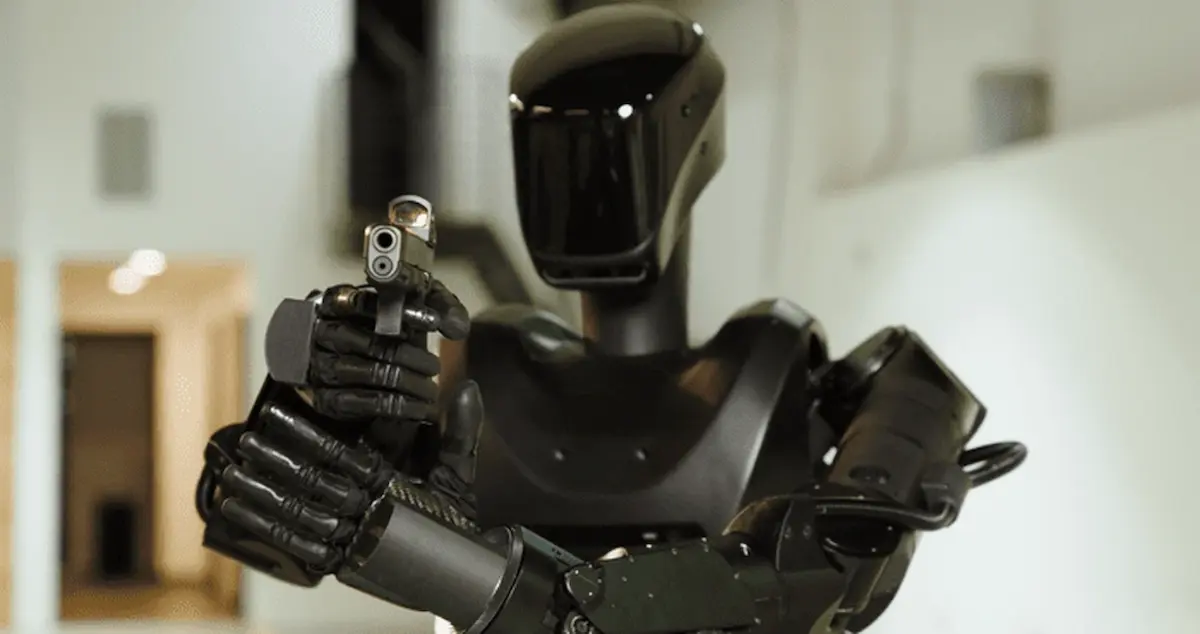 Robot Phantom MK-1 cầm súng lục tư thế sẵn sàng bắn, minh họa tải trọng mang vũ khí.