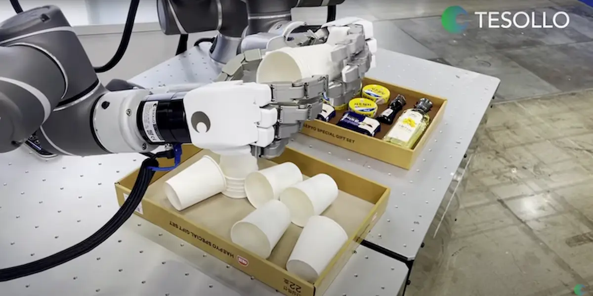 Bàn tay robot humanoid Tesollo thực hiện thao tác gắp cốc giấy khéo léo từ khay đựng.